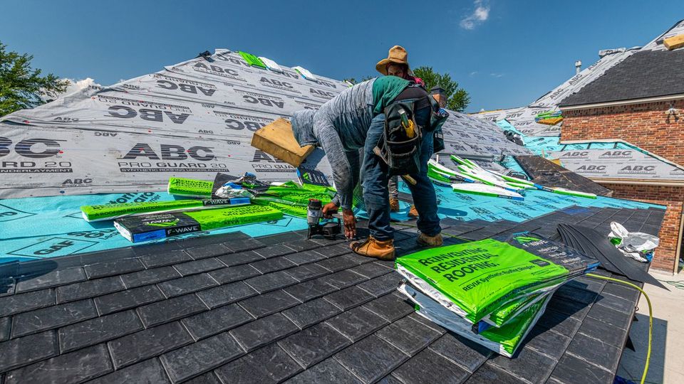 Couvreur posant des ardoises sur un toit en chantier